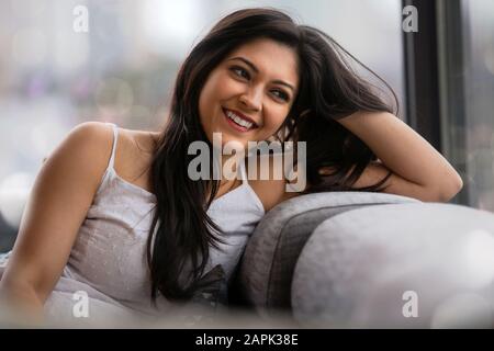 Belle jeune femme indienne américaine vivant un style de vie urbain à la maison dans l'appartement de ville, réussi et gai Banque D'Images