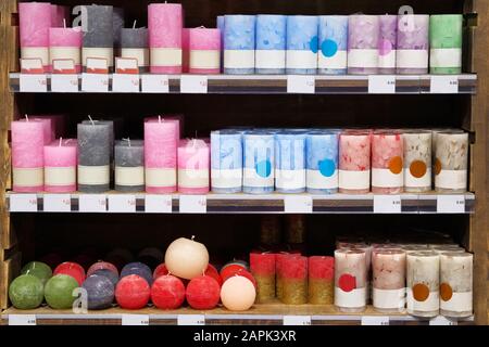 Bougies à vendre dans un magasin de décoration intérieure. Bougies parfumées colorées dans une grande boutique de bougies. Réductions sur les étiquettes de prix, vente. Banque D'Images