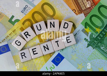 Cubes de lettres avec le mot allemand Grundrente, loyer au sol, sur les billets de banque Banque D'Images