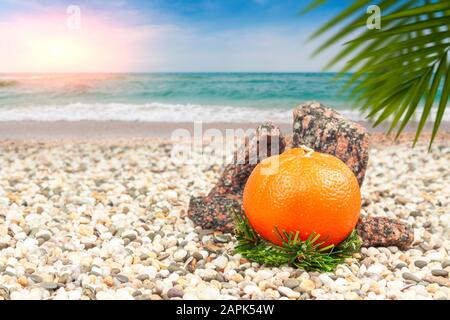 Bougie orange sur la rive sablonneuse d'une mer chaude. Banque D'Images