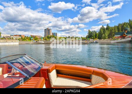 Un bateau en bois est amarré au coeur d'Alene Resort, avec le lancement de bateau, la marina et le parc McEuen à la distance derrière au lac coeur d'Alene Idaho Banque D'Images