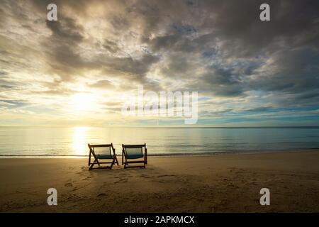 Deux chaises de plage se tenant sur la plage avec belle mer et lumière du soleil en arrière-plan à l'île de Phuket, Thaïlande. Été, Voyage, vacances et vacances c Banque D'Images