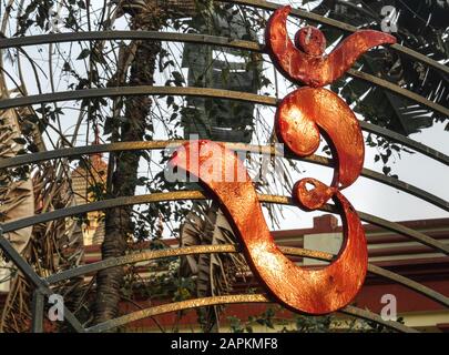 Symbole hindou traditionnel de la paix forgé en fer, orné d'une porte en fer à un temple sur les rives de la rivière Hooghly. Banque D'Images