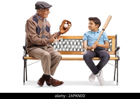 Homme âgé avec gant de base-ball et balle parlant à un garçon et assis sur un banc isolé sur fond blanc Banque D'Images