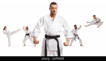 Karate maître avec ceinture noire debout devant les hommes et les femmes pratiquant les arts martiaux isolés sur fond blanc Banque D'Images