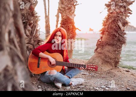 Portrait de la jeune femme jouant de la guitare sur la plage, Almunecar, Espagne Banque D'Images