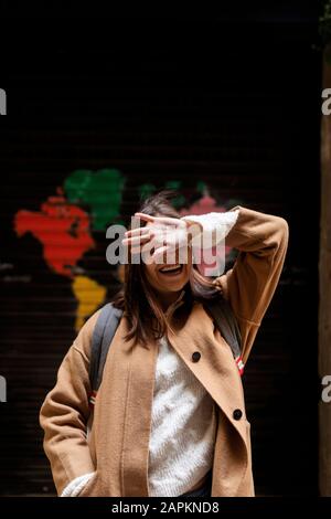Happy young woman couvrant son visage avec sa main Banque D'Images