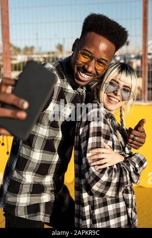 Portrait de rire de jeune couple prenant selfie avec smartphone Banque D'Images