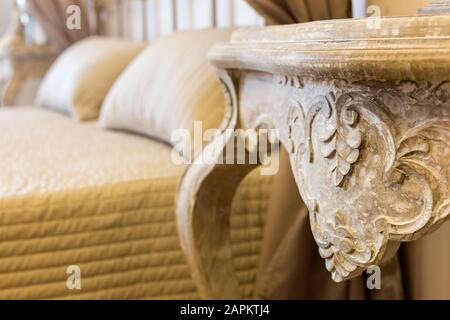 Mise au point sélective d'une table antique à côté du lit dans la chambre Banque D'Images