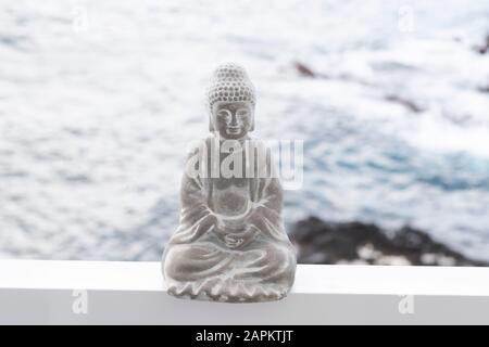 Figurine de bouddha en béton, océan en arrière-plan Banque D'Images