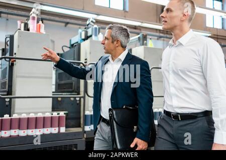 Deux hommes d'parler dans une usine Banque D'Images