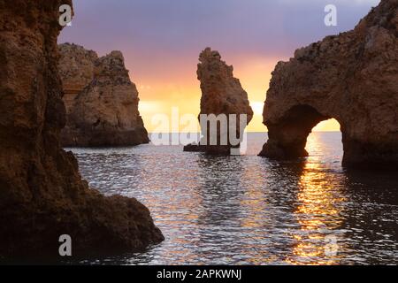 Portugal, Faro District, Lagos, arc naturel et formations rocheuses côtières à l'aube Banque D'Images