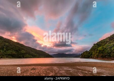 Nouvelle-Zélande, région de Marlborough, nuages au-dessus de Nikau Cove et du détroit de Kenepuru à l'aube de moody Banque D'Images