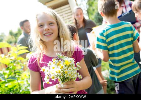 Les enfants d'école apprennent sur les herbes dans les études de la nature, fille tenant groupe de camomille Banque D'Images