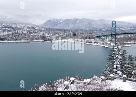 Vue sur le pont Lions Gate et l'ouest de Vancouver recouverte de neige avec des montagnes en arrière-plan. Tempête de neige et temps extrême à Vancouver. Banque D'Images