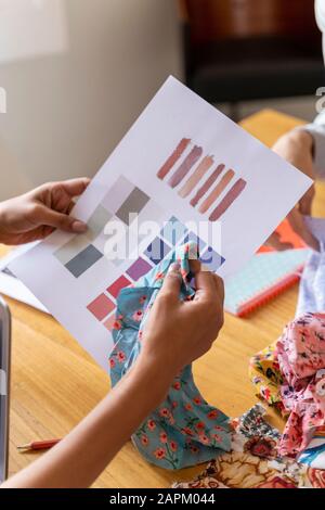 Le couturier tient un échantillon de couleur au bureau Banque D'Images