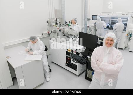 Portrait d'un scientifique souriant avec des collègues en laboratoire Banque D'Images