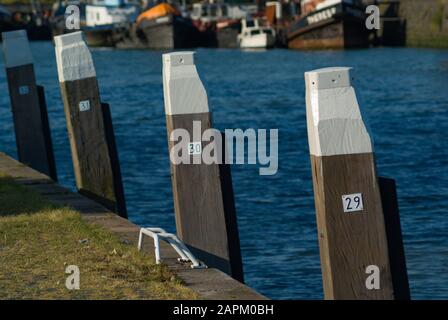 Bornes en bois dans l'eau avec différents numéros près de la port de Rotterdam Banque D'Images