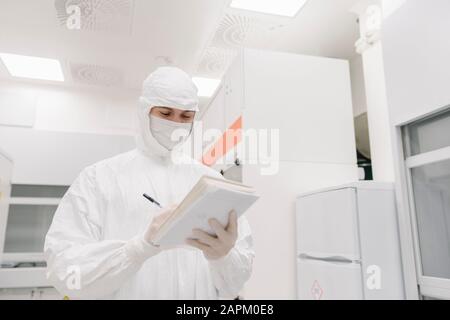 Scientist taking notes in laboratory Banque D'Images