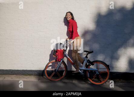 Jeune femme insouciante à vélo de location Banque D'Images