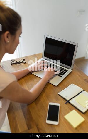 Adolescent féminin utilisant un ordinateur portable à la maison Banque D'Images