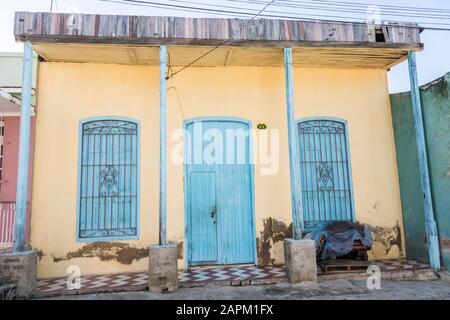 Une maison avec des portes et fenêtres peintes de couleur turquoise et extérieur jaune; Santiago de Cuba, Cuba. Banque D'Images