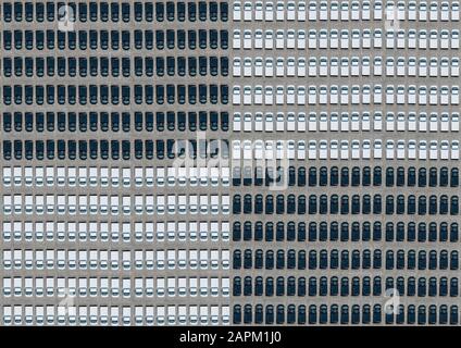 Vue aérienne d'un grand nombre de voitures noires et blanches disposées dans le parking Banque D'Images