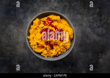 Bol de houmous de citrouille avec graines de sésame noir et de grenade Banque D'Images