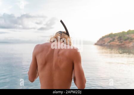 Vue arrière du jeune homme avec plongée libre sur la plage Banque D'Images