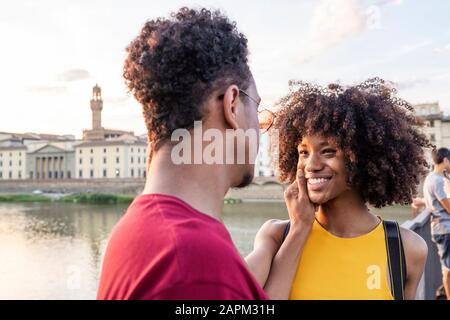 Heureux jeune couple touristique à la rivière Arno au coucher du soleil, Florence, Italie Banque D'Images