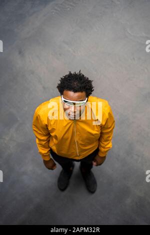 Homme d'âge mûr portant une veste jaune et debout sur la voie Banque D'Images