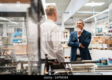 Deux hommes d'parler dans une usine Banque D'Images