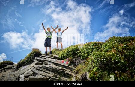 Garçon et fille debout sur le sommet de la montagne applaudisse, Passeier Valley, Tyrol du Sud, Italie Banque D'Images
