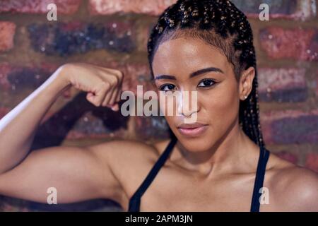 Athlète féminin flexing biceps, portrait Banque D'Images