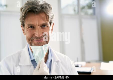 Portrait du médecin souriant avec masque dans sa pratique médicale Banque D'Images