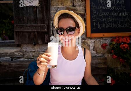 Femme qui aime un verre de babeurre dans une cabane de montagne, la vallée du Passeier, Tyrol du Sud, Italie Banque D'Images