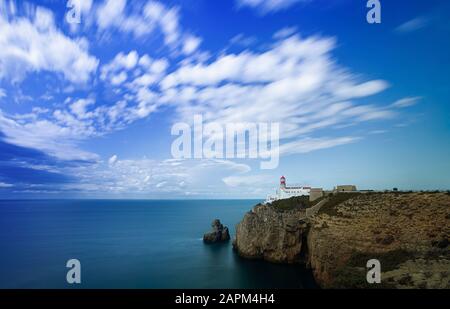 Portugal, Faro District, Lagos, nuages au-dessus du phare situé en bordure de la falaise côtière Banque D'Images