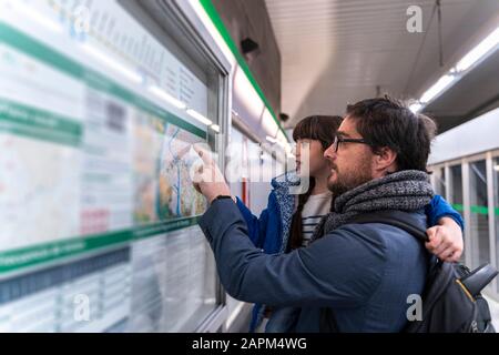 Père et fille regardant sur la carte à la station de métro Banque D'Images