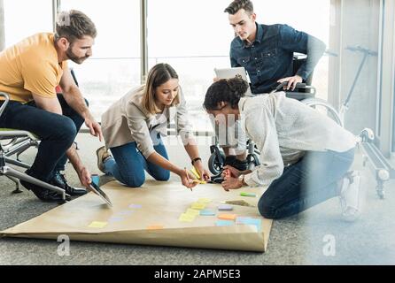 Jeunes gens d'affaires travaillant ensemble sur un projet au bureau Banque D'Images