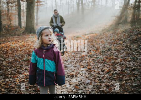 Mère avec filles pendant la promenade en forêt en automne Banque D'Images