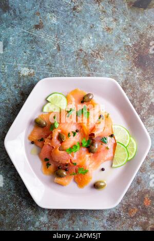 Viande de saumon crue à la chaux, aux olives et aux herbes Banque D'Images