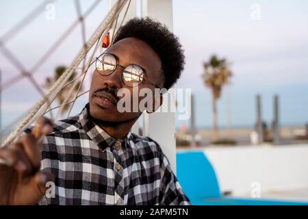 Portrait de jeune homme avec lunettes à bords métalliques Banque D'Images