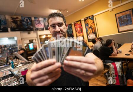 10 janvier 2020, Hessen, Francfort-sur-le-Main: Fabio Francisco de Sousa (34 ans), réalisateur d'une boutique Jk Entertainment, se tient dans sa boutique avec des cartes de trading du jeu "magique" dans sa main, où un tournoi "magique" se déroule photo: Frank Rumpenhorst/dpa Banque D'Images