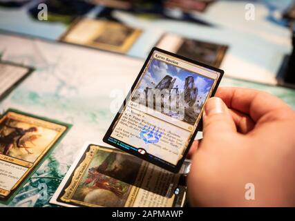 10 janvier 2020, Hessen, Francfort-sur-le-Main: Un participant à un tournoi du jeu de cartes de commerce 'Magic' détient l'une des cartes conçues avec imagination dans sa main. Les instructions sur la carte sont "Effectuer une prolifération" photo: Frank Rumpenhorst/dpa Banque D'Images