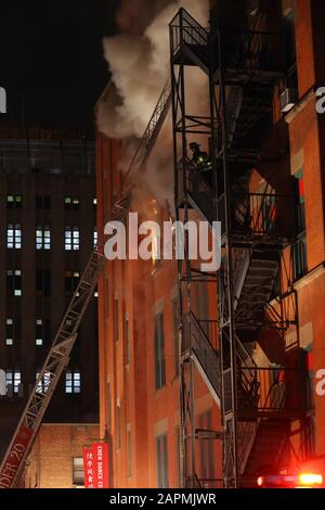 (New York, NY, 23 janvier 2020) 21:00. Un pompier monte une fuite d'incendie d'un centre communautaire sur le feu à 70 Mulberry St. L'incendie a éclaté sur le 4 Banque D'Images