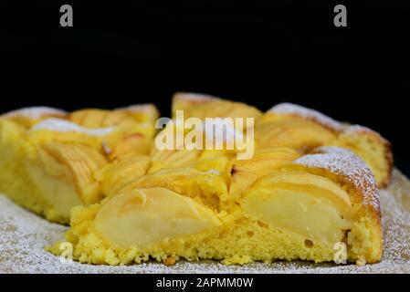 Gros plan d'une tarte aux pommes maison fraîche avec du sucre en poudre sur un fond sombre avec de l'espace pour le texte Banque D'Images