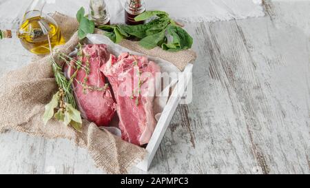 La côtelette de viande est prête à mariner et à cuisiner sur le barbecue. La viande est stockée sans plastique, dans du papier et du tissu respectueux de l'environnement. Espace de copie. Banque D'Images