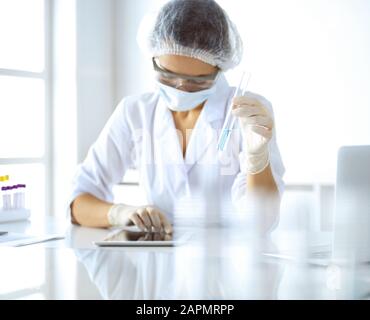 Professional female scientist in lunettes de protection recherche tube de réactifs de laboratoire. Concepts de la médecine et de la recherche Banque D'Images