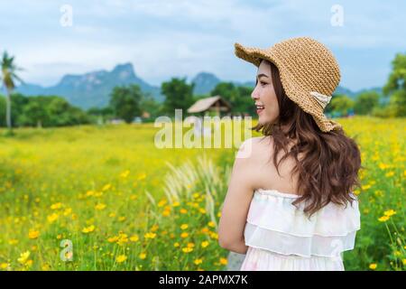 heureuse femme dans le champ de fleur de cosmos jaune Banque D'Images