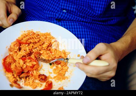 L'homme mange. Humain pendant une pause au travail, manger des pâtes. Banque D'Images